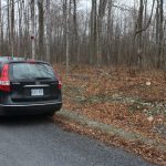 Car at edge of driveway opening