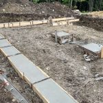 Poured footing with 2 pads for posts supporting the steel beam.